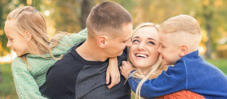 Portrait of young family playing in autumn park. Parents with children resting in the autumn parkの写真素材