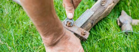 hand of an elderly man twisting the nut with a wrench outdoors. Repair by wrench.の写真素材