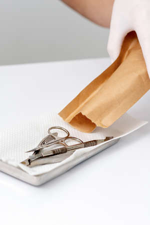 Female manicure master hand laying out manicure tools from craft envelopeの写真素材