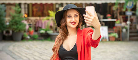 Beautiful young caucasian tourist woman takes a selfie in a European city