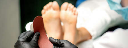 The pedicurist put on a new heel file on the metal handle before the procedure of cleaning the feet in a nail salonの写真素材