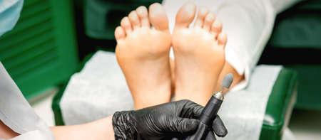 Chiropodist master prepares foot file machine before foot and toes clean treatment in a beauty salonの写真素材