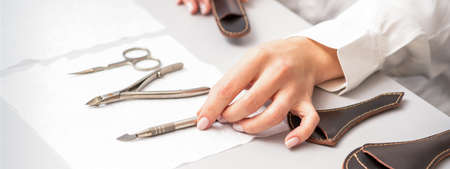 Manicure master lays out manicure set on a towel at the table in a nail salonの写真素材