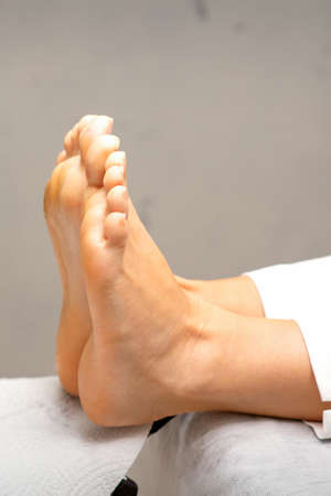 Beautiful feet with during pedicure lying on the couch in beauty salon close upの写真素材