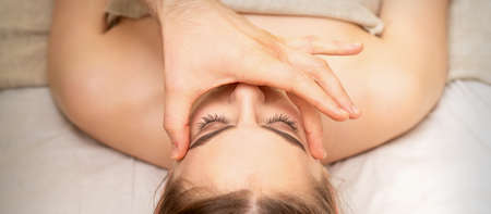 Face massage with fingers of a masseur. Female facial skin care at a beauty spa salonの写真素材