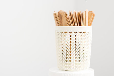 Sticks of wood for wax in white basket isolated on white background with copy spaceの写真素材
