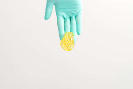 Yellow sugar paste in hand master of depilation. Smiling beautician holding wax for depilation over...