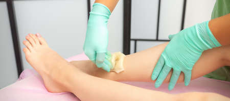 Waxing depilation procedure for removing hair on legs with sugaring paste in the beauty salonの写真素材
