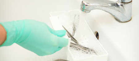 Hand in glove cleans the tweezers with water in-tray. Cleaning systems for tweezersの写真素材