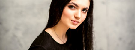 The fashionable young woman. Portrait of the beautiful female model with long hair and makeup....