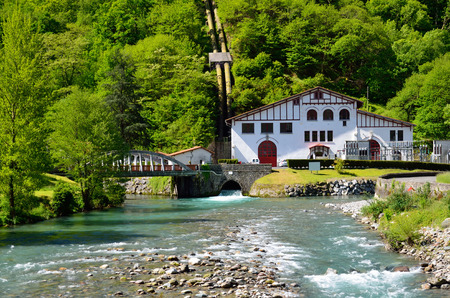 Small hydroelectric power station is situated near the swift river under the forested mountain in the Pyrenees  Its building is made in the traditional Basque style  の写真素材