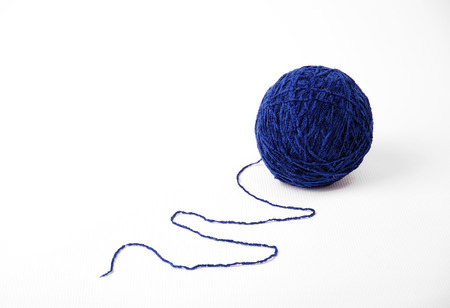 Single blue skein lies on white background  End of cotton thread is located as a wave  