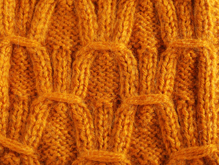 Knitted fabric is made by hand and photographed closely  It is decorated with pattern 