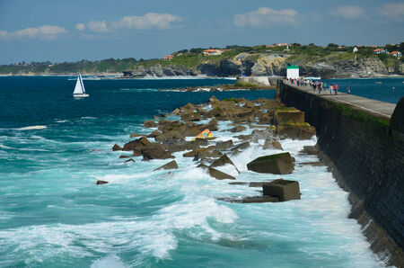 Many vacationers are walking along the seawall at low tide in the vicinity of Saint-Jean-de-Luz 