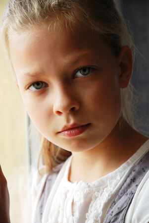 Pre-teen girl is looking seriously at camera.の写真素材