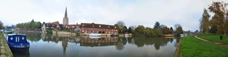 There are traditional houses in the ancient street and boats mooring on the Thames river in the oldest town in Britain.のeditorial素材