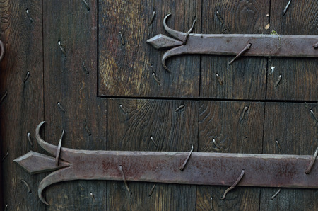 Old wooden door is armoured with iron stripes.の写真素材