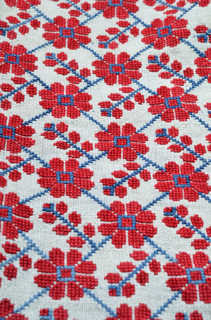 The old-fashioned handmade embroidery is photographed closely. The net of floral motives is made by...
