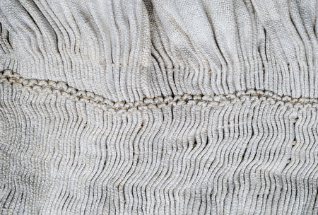 The white homespun cloth is kilted and decorated with a handmade embroidery.