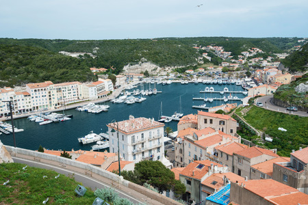 There are many various vessels in the harbor and residential buildings on the narrow shelf in the bottom part of Bonifacio.の写真素材