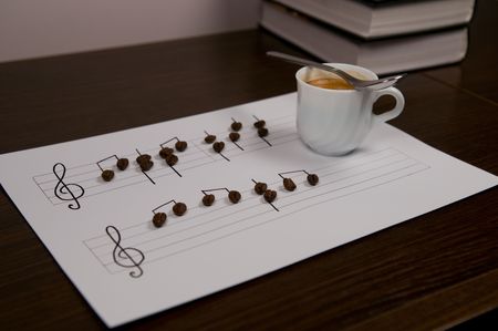 Grains and a coffee cup on sheet of a musical paperの写真素材