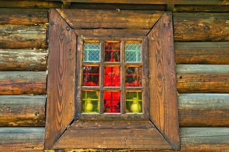 Window is in the wooden wall of old, rural  churchの写真素材