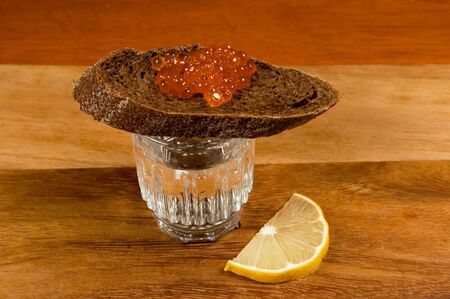 Glass of vodka and   sandwich with red caviarの写真素材