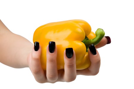 Juicy, yellow pepper in a hand, it is isolated on a white background.