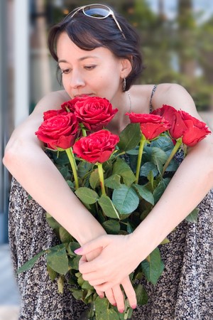 The woman with the big bouquet of red rosesの写真素材