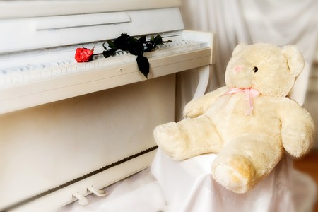 The white piano, red rose and children's toy. Partial degradation of a pictureの写真素材