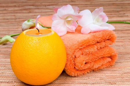 Orange towel, and a burning candle in citrusの写真素材