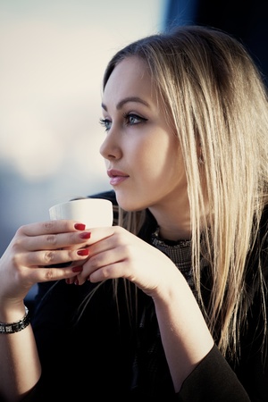 Young blonde woman drinking tea in the cafeの写真素材