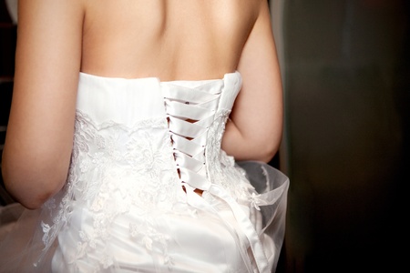 Bride being laced into a wedding dressの写真素材