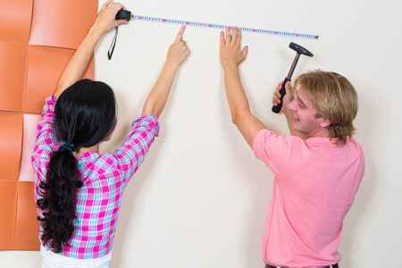 Couple chooses a place for a picture with the help of measuring tapeの写真素材