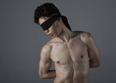 Young man of Asian appearance with a blindfoldの写真素材