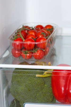 Fresh food, vegetables and fruits on the shelves in the fridgeの写真素材