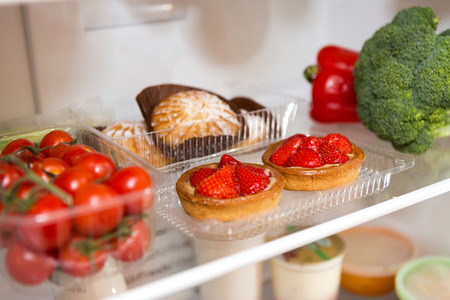 Sweet pastries and healthy food in the fridge