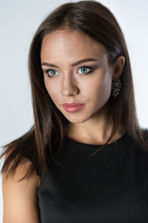 Beautiful young woman in black dress on white backgroundの写真素材