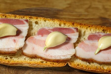 Sandwich with bacon and garlics on wooden backgroundの写真素材