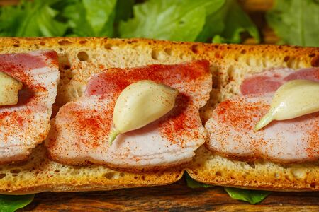 Sandwich with bacon and garlics on wooden backgroundの写真素材