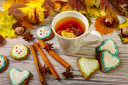 Autumn tea party with glazed gingerbread and spices on wooden backgroundの写真素材