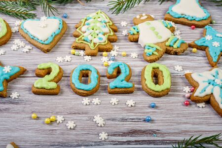 Glazed Christmas gingerbread and Christmas tree branches on a wooden backgroundの写真素材
