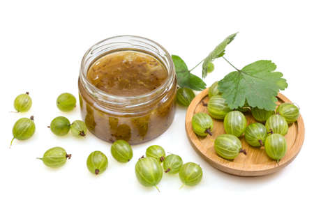 Jam in a glass jar and fresh gooseberry berries, isolated on a white backgroundの写真素材