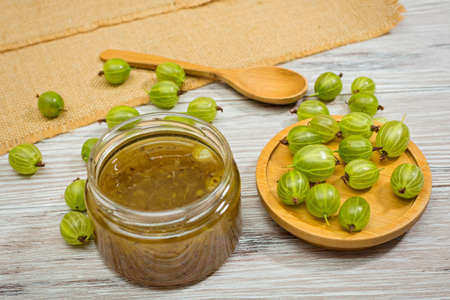 Gooseberry jam and fresh berries, on a light wooden backgroundの写真素材