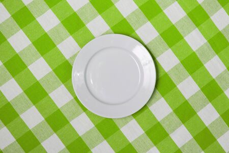 white round plate on green checked tableclothの写真素材