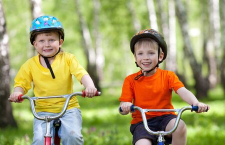 little children riding their bikes in parkの写真素材