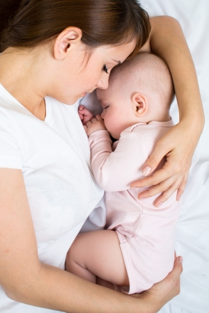 Young mother and her baby sleeping togetherの写真素材