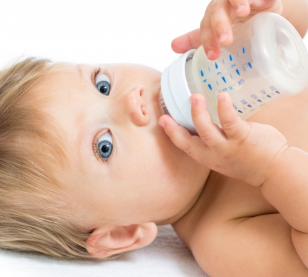 Pretty baby girl drinking milk from bottleの写真素材