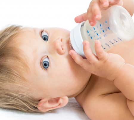 Pretty baby girl drinking milk from bottle