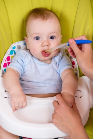 Little baby feeding with a spoonの写真素材
